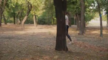 Genç bir bayan koşucu bir yaz parkında antrenman yapıyor. Dışarıda koşan kadınlar için spor salonu.