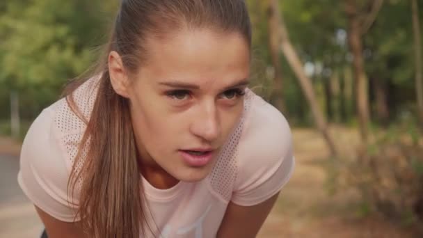 公園でマラソンを走った後 疲れた少女ジョガー呼吸 朝のランニングコンセプト — ストック動画