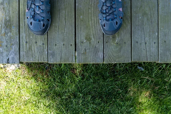 Person standing on the edge of a wooden deck — Stock Photo, Image