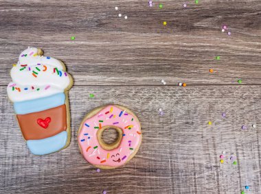 Ahşap bir arka planda latte ve donut şekerli kurabiyeler.