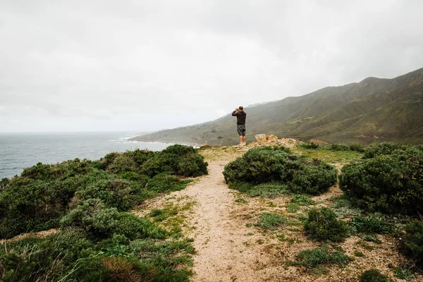 Yeşil fırça ve bir adam fotoğraf çekerek dağlarda Pathway