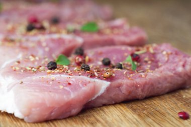 Biftekler baharat ve otlarla serpilir. Bir barbekü yakın çekim için sulu biftek.