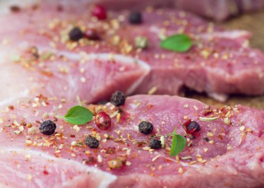 Biftekler baharat ve otlarla serpilir. Bir barbekü yakın çekim için sulu biftek.