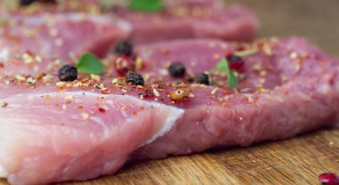 Biftekler baharat ve otlarla serpilir. Bir barbekü yakın çekim için sulu biftek.