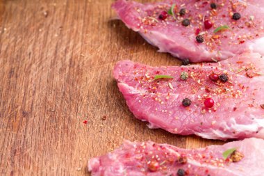 Çiğ domuz biftek baharat ve otlar serpilir. Barbekü için sulu çiğ biftek, yakın.