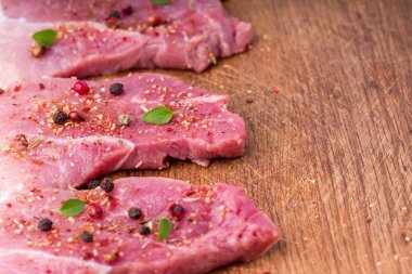 Çiğ domuz biftek baharat ve otlar serpilir. Barbekü için sulu çiğ biftek, yakın.