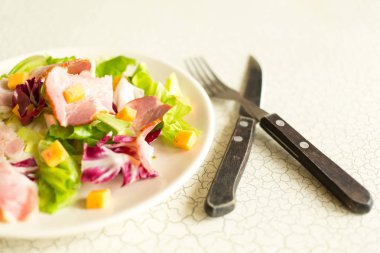 Bir tabak salata, yeşil yaprakları, jambon ve peynir. Çatal bıçak takımı ve bir tabak taze salata. Öğle Yemeği. InterContinental kahvaltı otelde.