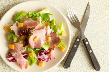 Bir tabak salata, yeşil yaprakları, jambon ve peynir. Çatal bıçak takımı ve bir tabak taze salata. Öğle Yemeği. InterContinental kahvaltı otelde.