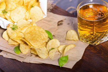 Tuz ve Yeşiller'de bir tabloda bir bar bira bir arka plan üzerinde patates cipsi. Yeşil bira için bir çerez olarak patatesler. Ekim bira Fest. 