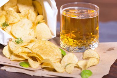 Tuz ve Yeşiller'de bir tabloda bir bar bira bir arka plan üzerinde patates cipsi. Yeşil bira için bir çerez olarak patatesler. Ekim bira Fest. 