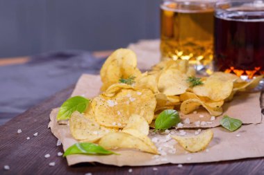 Tuz ve Yeşiller'de bir tabloda bir bar bira bir arka plan üzerinde patates cipsi. Yeşil bira için bir çerez olarak patatesler. Ekim bira Fest. 