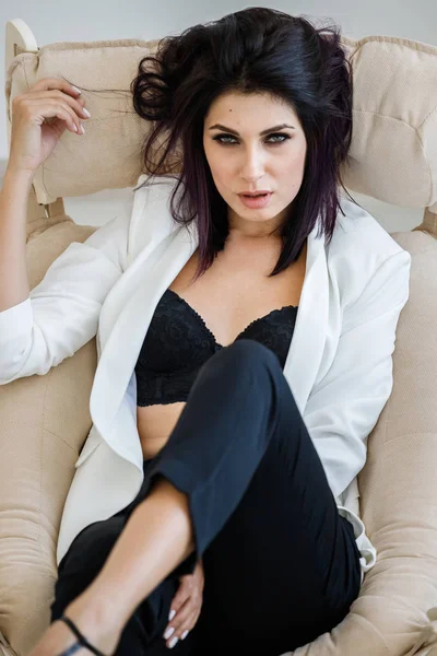 Siyah pantolon, beyaz ceket ve siyah sütyen, ev İçişleri, koltuk yalan giyen güzel esmer kadın portresi stüdyo 