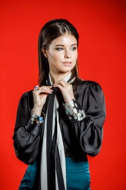 Genç model kırmızı bir arka plan üzerinde rahat kıyafetler içinde stüdyo portre. Siyah gömlek ve mavi etek stüdyoda poz genç kadın 