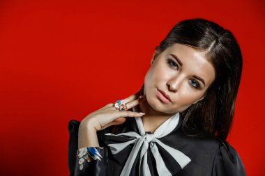 Portre stüdyo portre rahat kıyafetler genç modeli. Üzerinde kırmızı bir arka plan üzerinde boyun duran yay ile siyah gömlek giymiş şık saç kesimi, Genç kadınla 