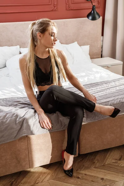 Schöne Blonde Mädchen Schwarzen Lässigen Kleidern Sitzt Auf Dem Bett — Stockfoto