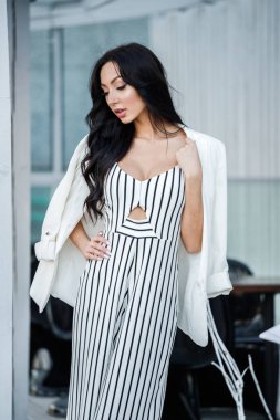 Çizgili siyah beyaz elbiseli güzel genç esmer kadın açık portresi. Kafe iç duran kıvırcık kadın