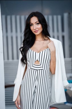 Çizgili siyah beyaz elbiseli güzel genç esmer kadın açık portresi. Kafe iç duran kıvırcık kadın