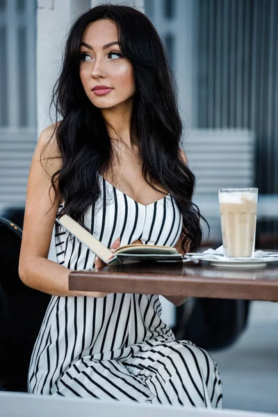 줄무늬 검은색과 드레스에 여자의 초상화 커피를 마시고 인테리어에서 — 스톡 사진