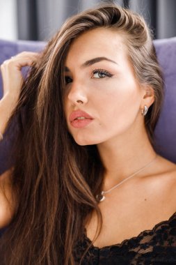 Stüdyo mor pijama genç esmer kadın portresi. Güzellik kadını ev iç, mor koltuk oturma