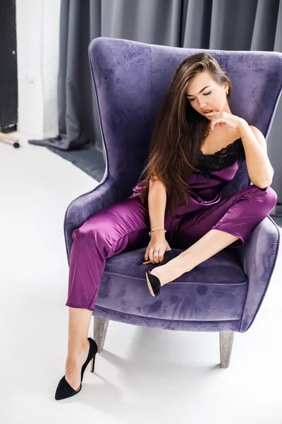 Stüdyo mor pijama genç esmer kadın portresi. Güzellik kadını ev iç, mor koltuk oturma