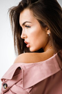 Pembe ceket ayakta beyaz stüdyo arka plan üzerinde giyen güzel esmer kadın portresi portre