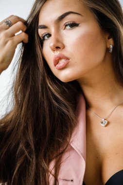 Pembe ceket ayakta beyaz stüdyo arka plan üzerinde giyen güzel esmer kadın portresi portre