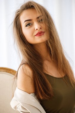 Moda studio güzellik kadın model lüks daireler ahşap sandalye üzerinde oturan bir kadeh. Profesyonel makyaj otel iç rahat kıyafetler giymiş olan kadın.