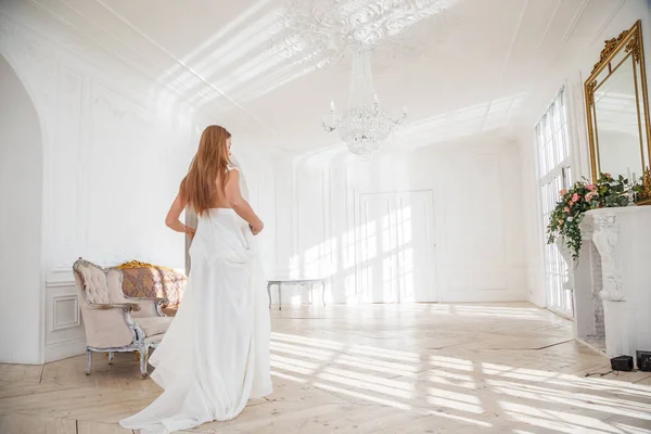 时装拍摄的美丽的金发女子白色礼服站在白色的内部背景 — 图库照片