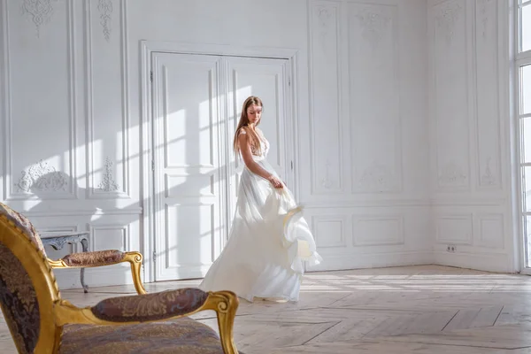 时装拍摄的美丽的金发女子白色礼服站在白色的内部背景 — 图库照片
