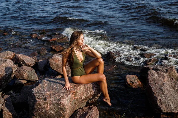 美丽的黑发女人在阳光下的肖像 白天在岩石海滩上穿着泳衣的模特 — 图库照片