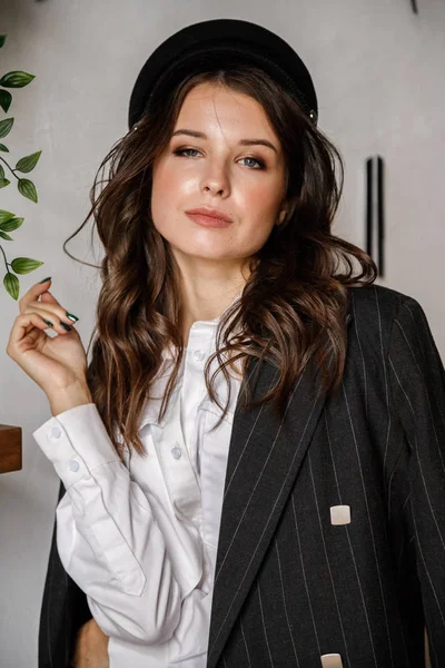 Fashion portrait of beauty brunette model wearing black jacket, white shirt and pink pants. Young beautiful woman posing in luxury apartments interior