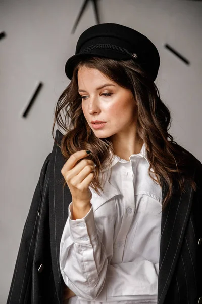 Fashion portrait of beauty brunette model wearing black jacket, white shirt and pink pants. Young beautiful woman posing in luxury apartments interior