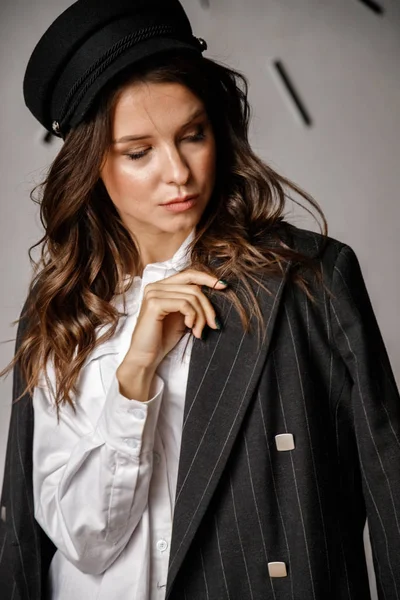 Fashion portrait of beauty brunette model wearing black jacket, white shirt and pink pants. Young beautiful woman posing in luxury apartments interior