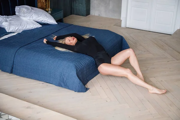 여자의 스튜디오 아파트 인테리어에서 침대에 가까운 포즈를 취하는 — 스톡 사진