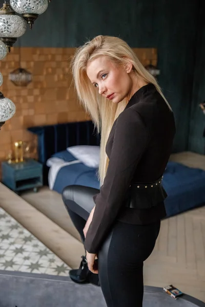 黒のレギンスとジャケットのアパートのインテリアでポーズでセクシーなブロンドの女の子 — ストック写真