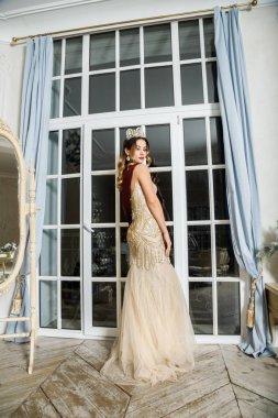 Bej Güzellik esmer modelinde portresi lüks iç pencereye yakın duran elbise 