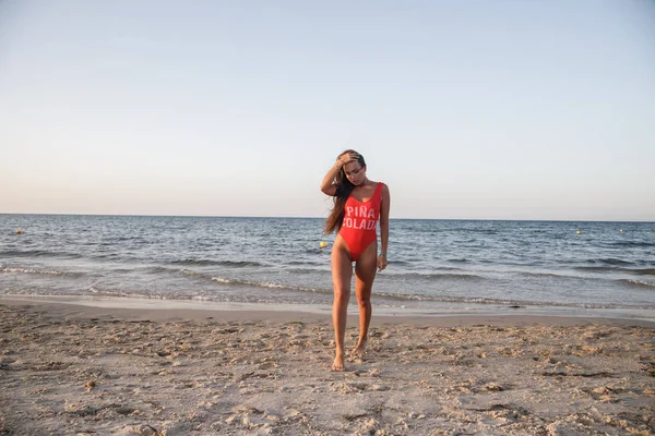 Молода Брюнетка Червоному Купальнику Стоїть Піщаному Пляжі Вдень — стокове фото