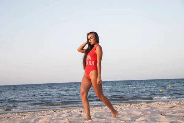 Молодая Брюнетка Красном Купальнике Стоит Днем Песчаном Пляже — стоковое фото