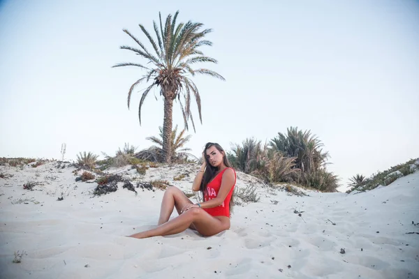 Young Brunette Woman Wearing Red Swimsuit Sitting Sandy Beach Daytime — Stock Photo, Image