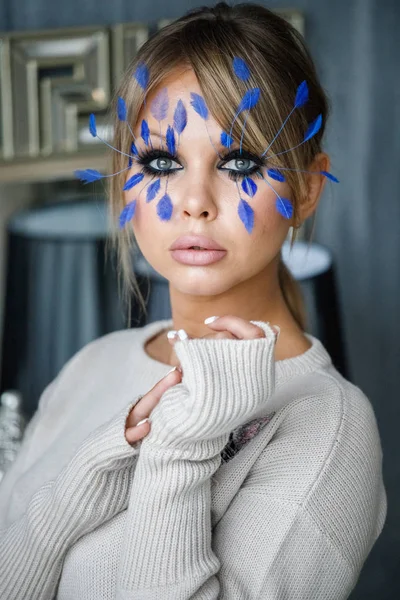 럭셔리 아파트 인테리어에 얼굴에 파란색 깃털으로 메이크업으로 모델의 초상화 — 스톡 사진