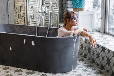 Banyo beyaz giysili güzel sarışın kadın. Yüzündeki küçük mavi tüyleri ile şık makyaj modeliyle Güzellik Portresi