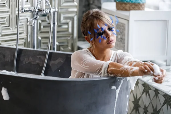 Banyo Beyaz Giysili Güzel Sarışın Kadın Yüzündeki Küçük Mavi Tüyleri — Stok fotoğraf