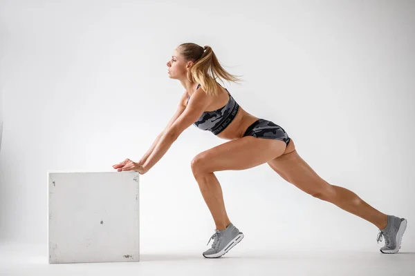 运动年轻女子的工作室镜头在运动服 美容模型做健身锻炼 白色墙壁背景 — 图库照片