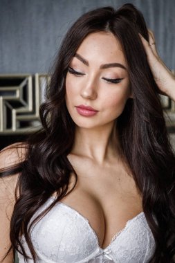 Beyaz iç çamaşırı giyen güzel esmer kadın stüdyo portresi. Charming güzellik modeli daire iç poz  
