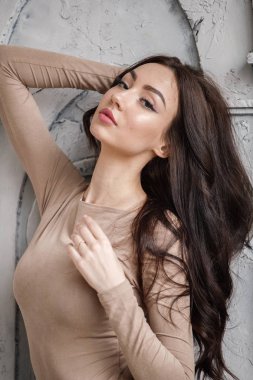 Bej giysi giyen güzel esmer kadın stüdyo portresi. Charming güzellik modeli daire iç poz  