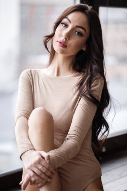 Bej giysi giyen güzel esmer kadın stüdyo portresi. Charming güzellik modeli daire iç poz  