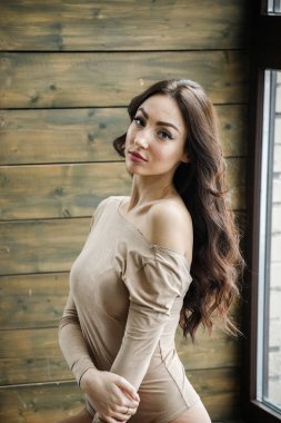 Bej giysi giyen güzel esmer kadın stüdyo portresi. Charming güzellik modeli daire iç poz  