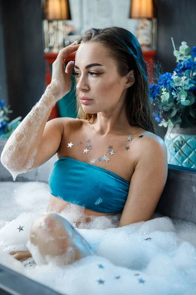 青いランジェリーで現代的なバスルームのインテリアでお風呂に入る美しさの若い女性のクローズアップ肖像画 — ストック写真
