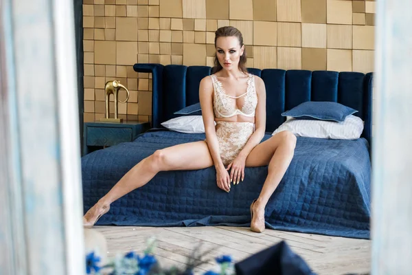 아름다움 금발의 아파트 인테리어에서 침대에 화이트 란제리의 세련된 모델의 초상화 — 스톡 사진