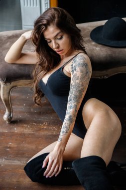 Siyah iç çamaşırlı güzel, uzun saçlı esmer ve apartman dairesinde poz veren siyah çizmeli. 